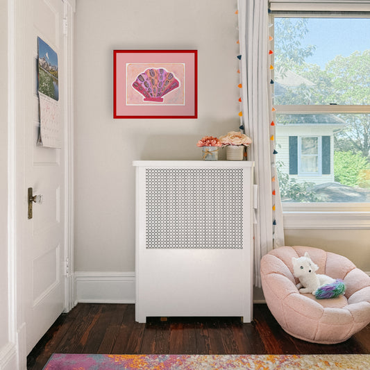 A cozy corner with a white heater cover, a vibrant shell artwork on the wall, and a plush pink pet bed next to a large window.