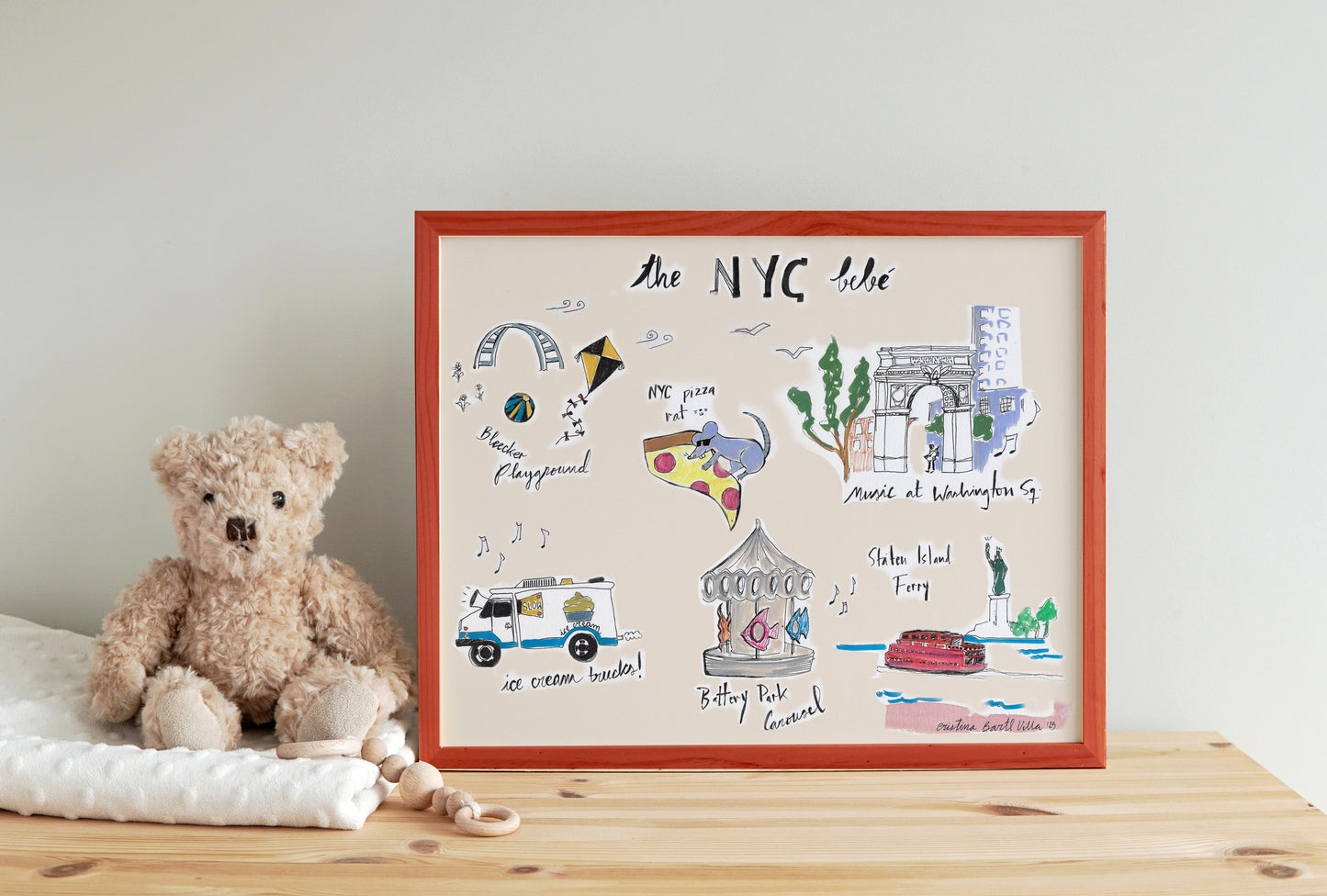 A colorful illustrated map of NYC featuring landmarks and a teddy bear on a wooden table.