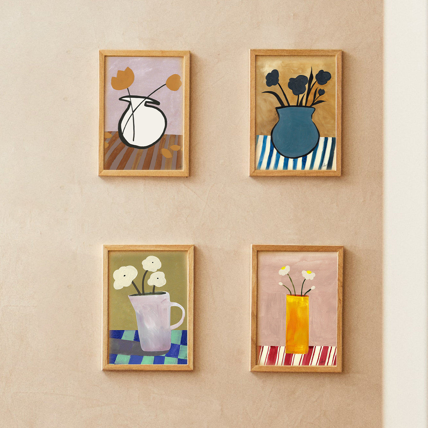Four framed abstract floral paintings arranged on a textured wall.
