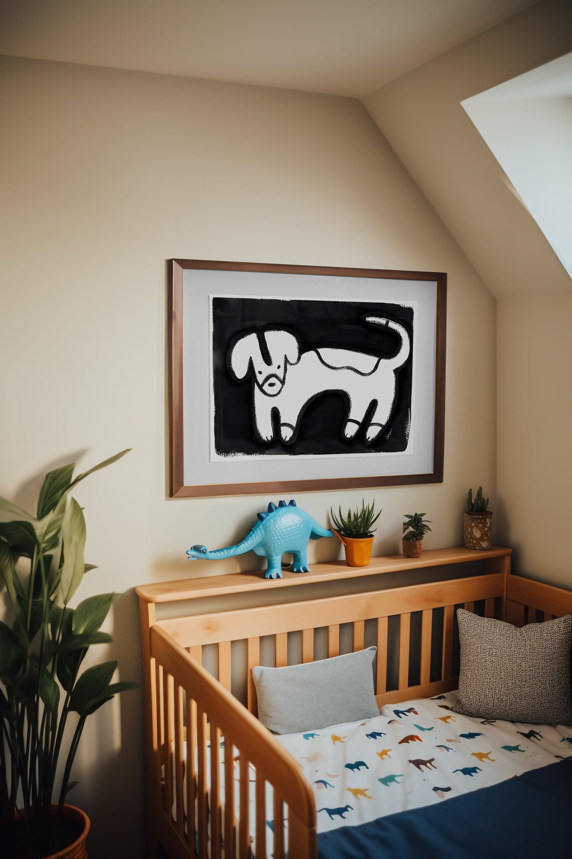 Nursery decor featuring a framed dog painting and a crib with playful bedding.