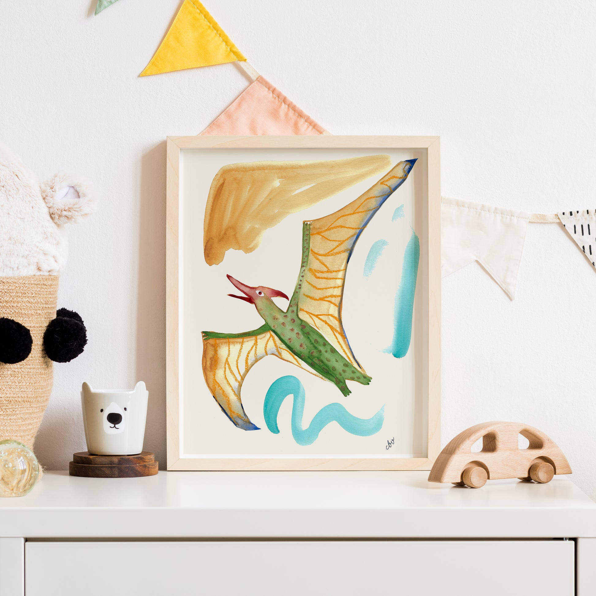Colorful artwork of a flying creature displayed on a shelf with decorative elements.