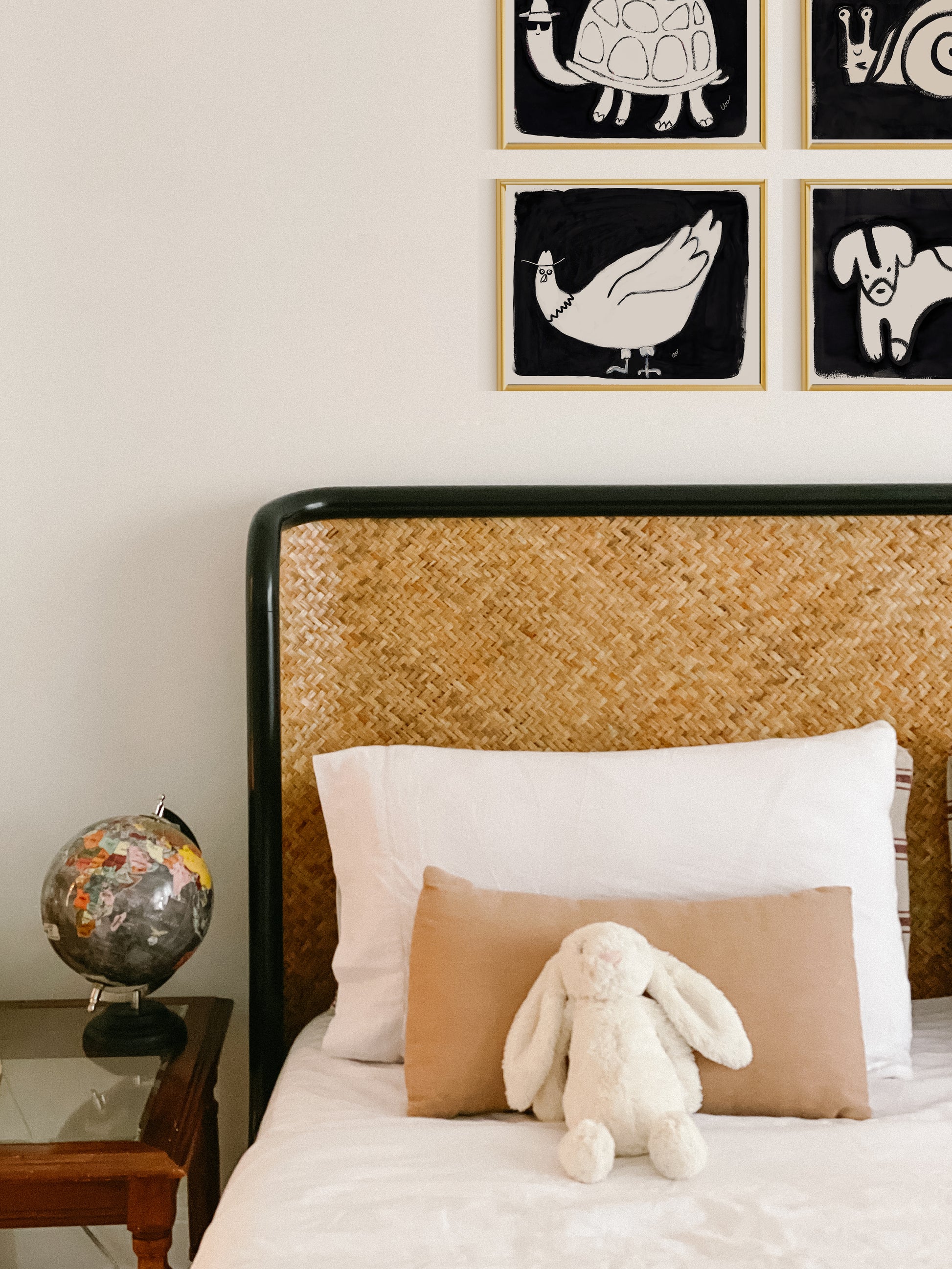 A cozy bedroom featuring a woven headboard, a plush bunny on the bed, and decorative animal prints on the wall.