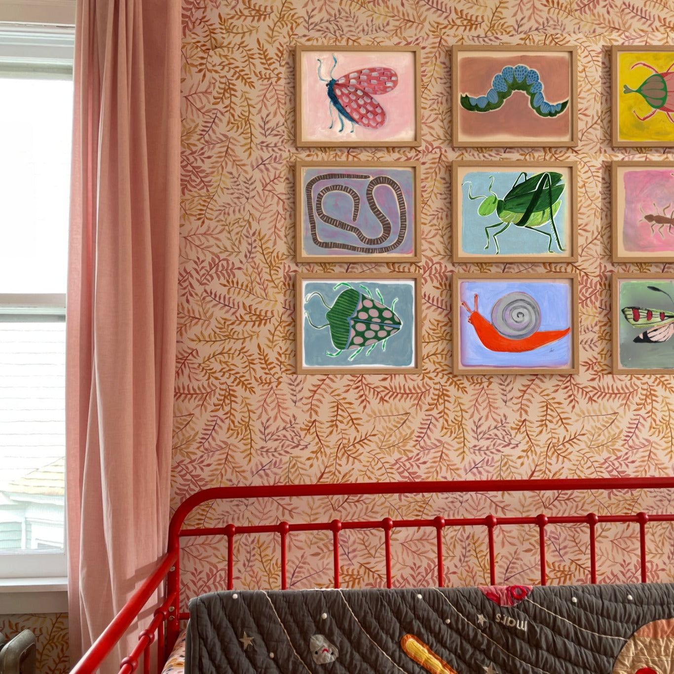 Decorative children's artwork featuring insects and nature-themed designs on a vibrant wall in a nursery.