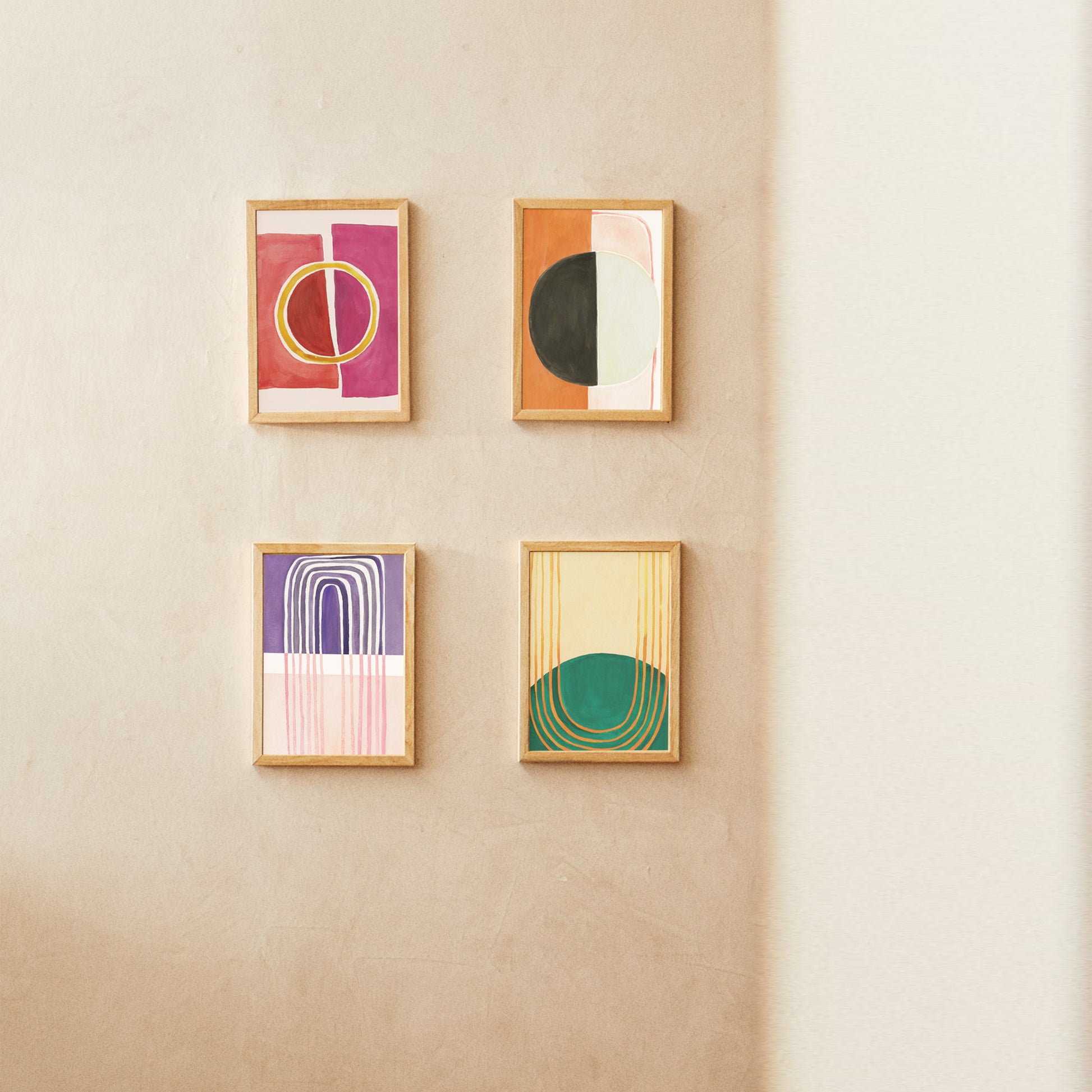 Four framed abstract art pieces displayed on a textured wall.