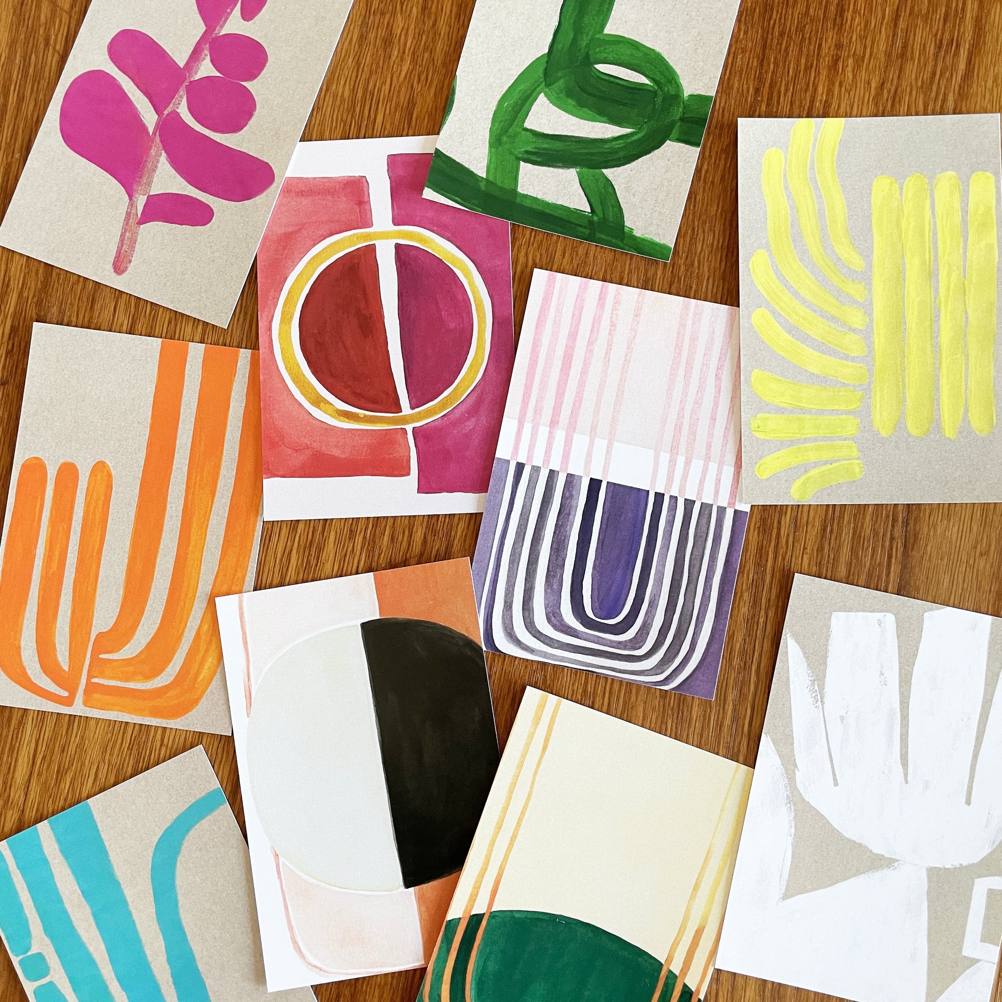 Colorful abstract art cards arranged on a wooden surface
