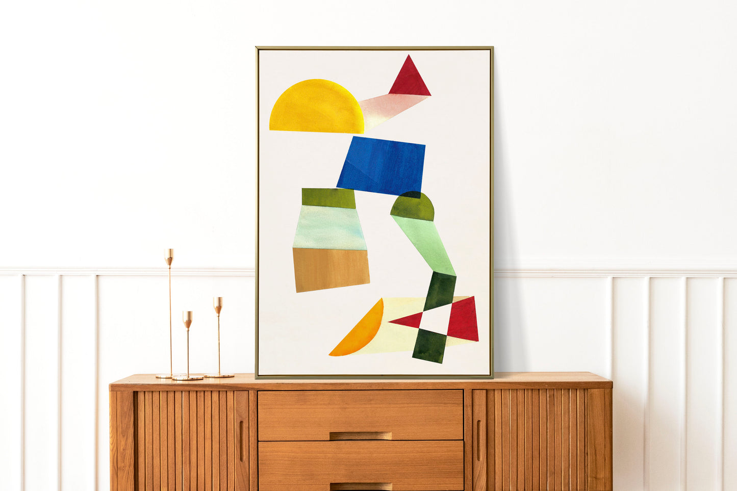Abstract artwork featuring geometric shapes in various colors displayed on a wooden sideboard.