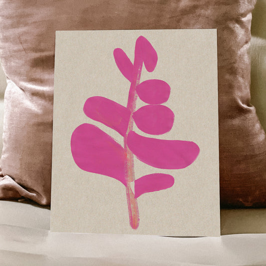 A pink abstract leaf design on a beige background placed on a sofa.