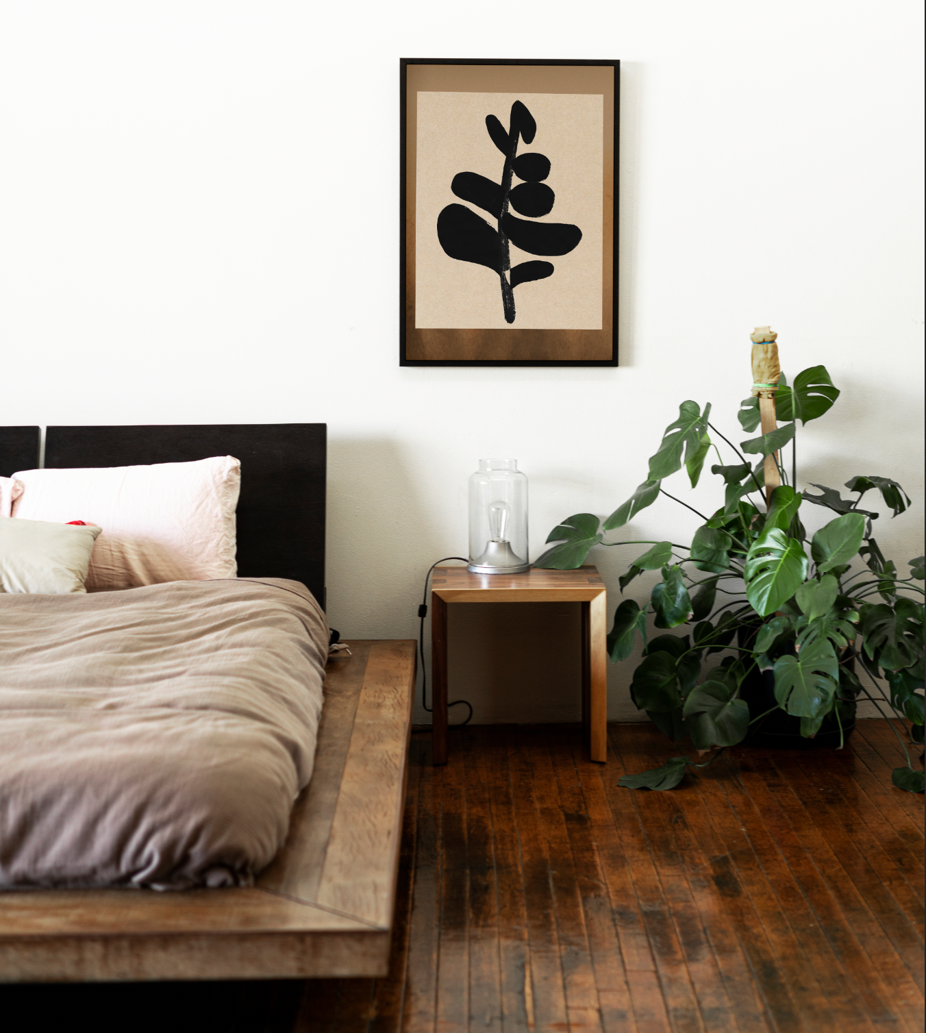 A cozy bedroom featuring a wooden bed, a framed artwork on the wall, and a potted plant beside a nightstand.